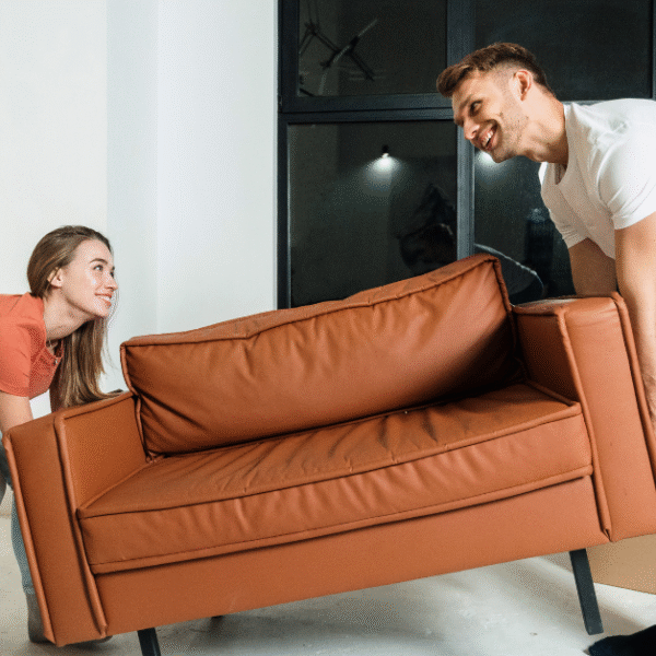 a couple is moving a small sofa in their flat