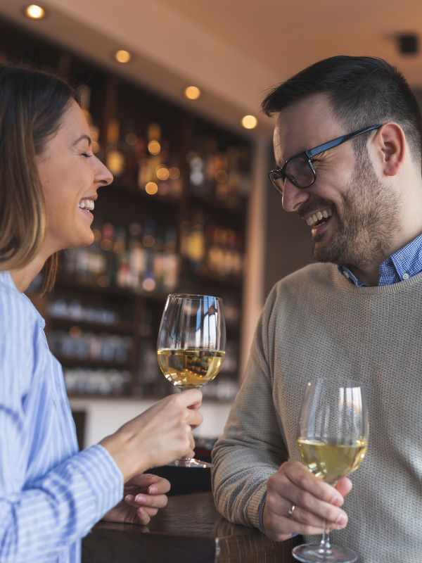 happy-couple-laughing-and-drinking-wine