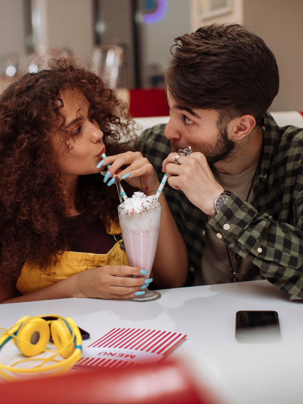 two-young-lovers-drinking-from-the-same-glass