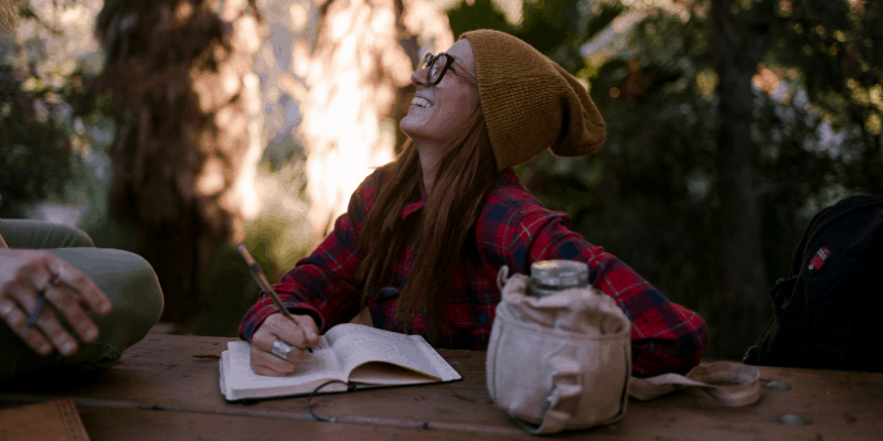 woman-laughing-writing-in-a-journal
