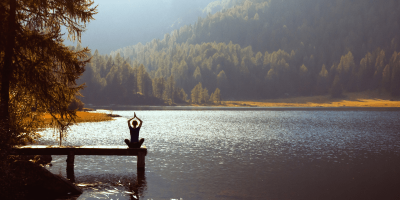 woman-meditating-on-a-river-porch