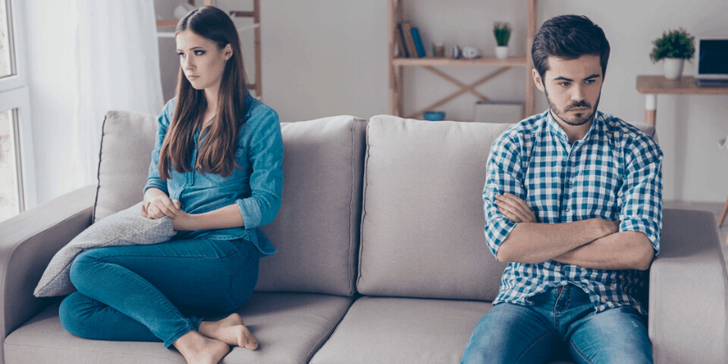 couple-on-couch-avoiding