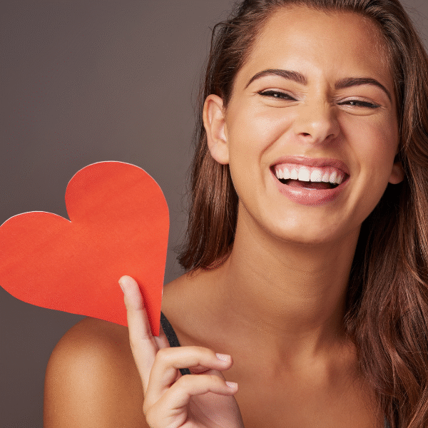 woman-smiling-with-a-paper-heart