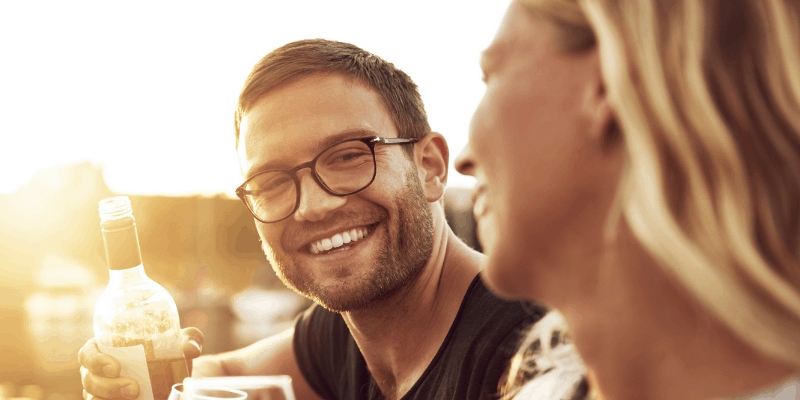 photo of a couple enjoying and smiling, the man holding a bottle in his hand