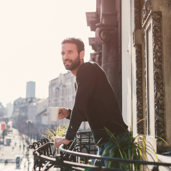 man-drinking-coffee-on-a-balcony