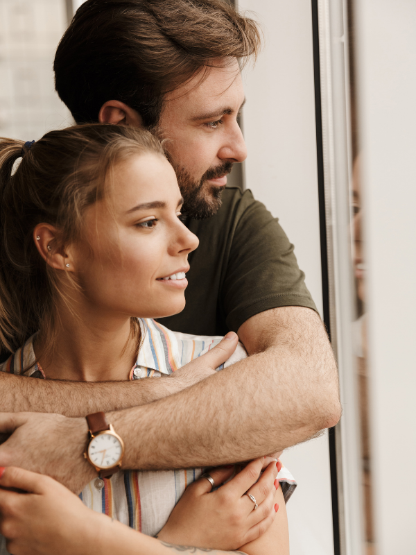 couple hugging next to the window