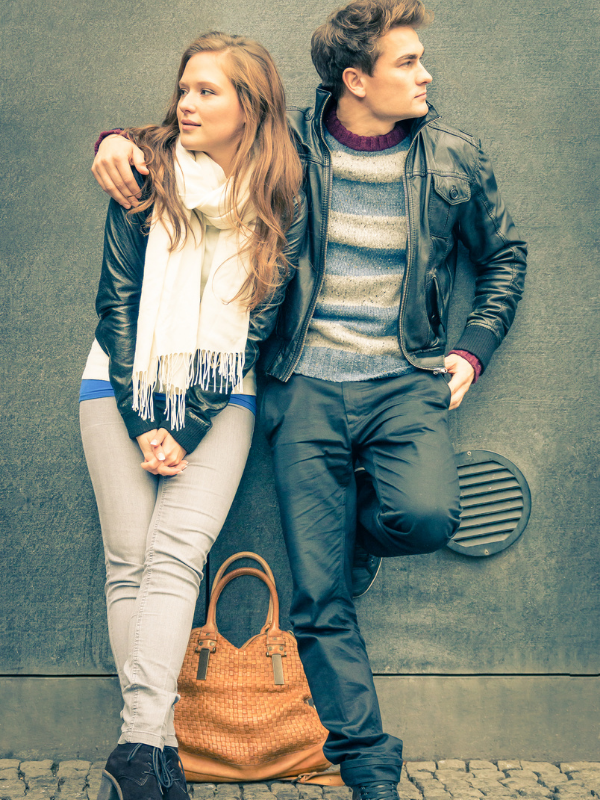 young couple leaning on a wall