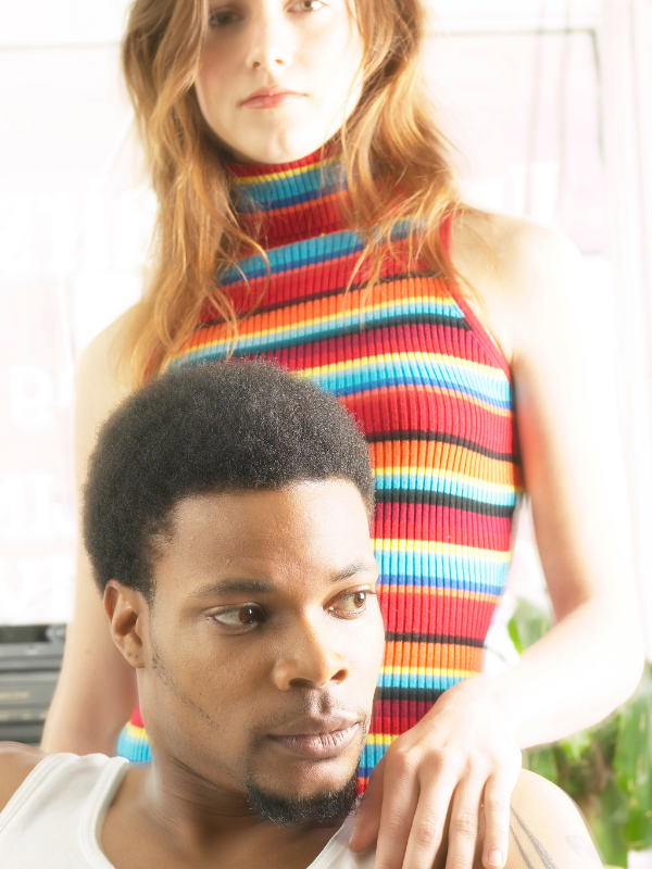 woman standing behind a man as he looks away