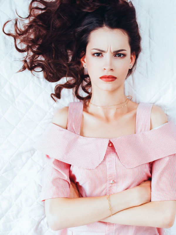 woman on the bed annoyed