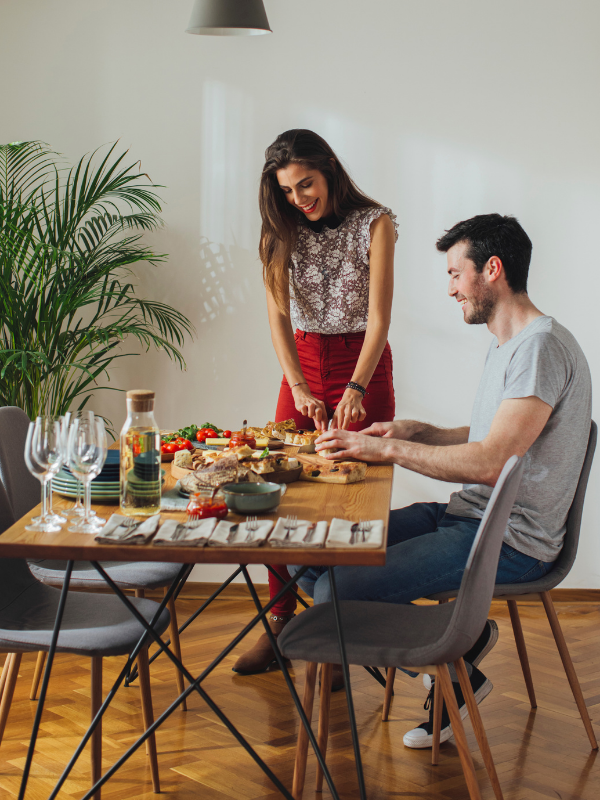 woman cutting food next to her boyfriend