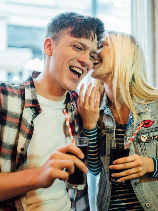 woman telling her boyfriend something funny both laughing