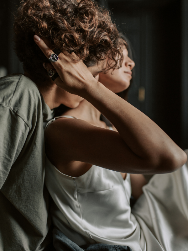 man kissing a woman's neckline